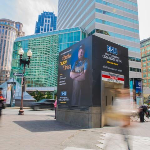 A UNE advertisement adorns a subway entrance in downtown Boston, Mass.